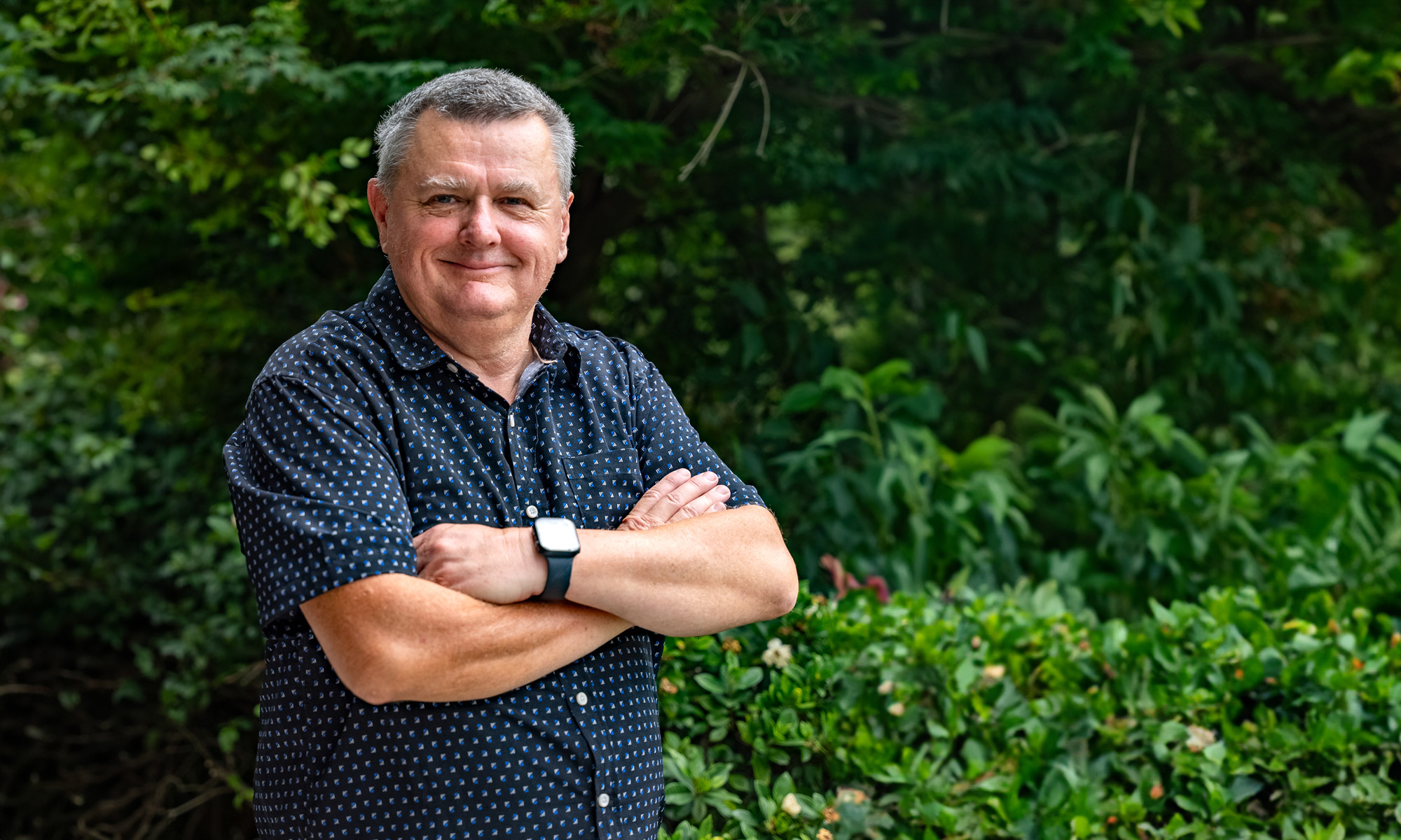 Portrait of Dave Brebner standing in a garden